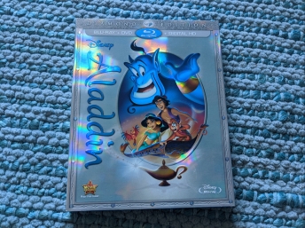 Cover of Aladdin Blu-Ray on a pale aqua rug