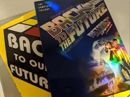 Back to the Future The Complete Trilogy DVD case in front of book cover for Back to Our Future by David Sirota